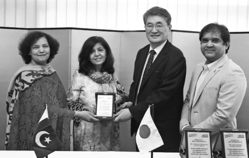 Japanese Consul General Isumura Toshikazu handing a shield to the chief coordinator of Kaus-e-Kazah Welfare Organisation, Fauzia Mughees after signing an MoU for upgradation of a girls primary school in Dadu district with a grant-in-aid from the Japanese government.